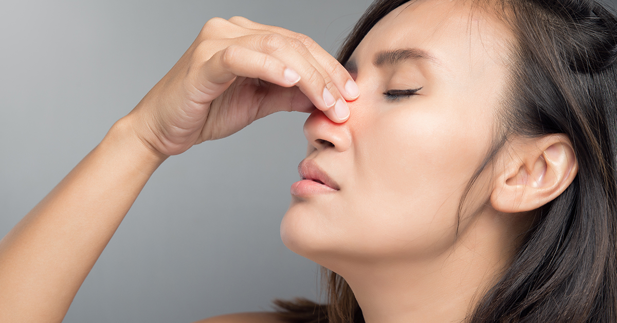 Close-up of person holding their nose